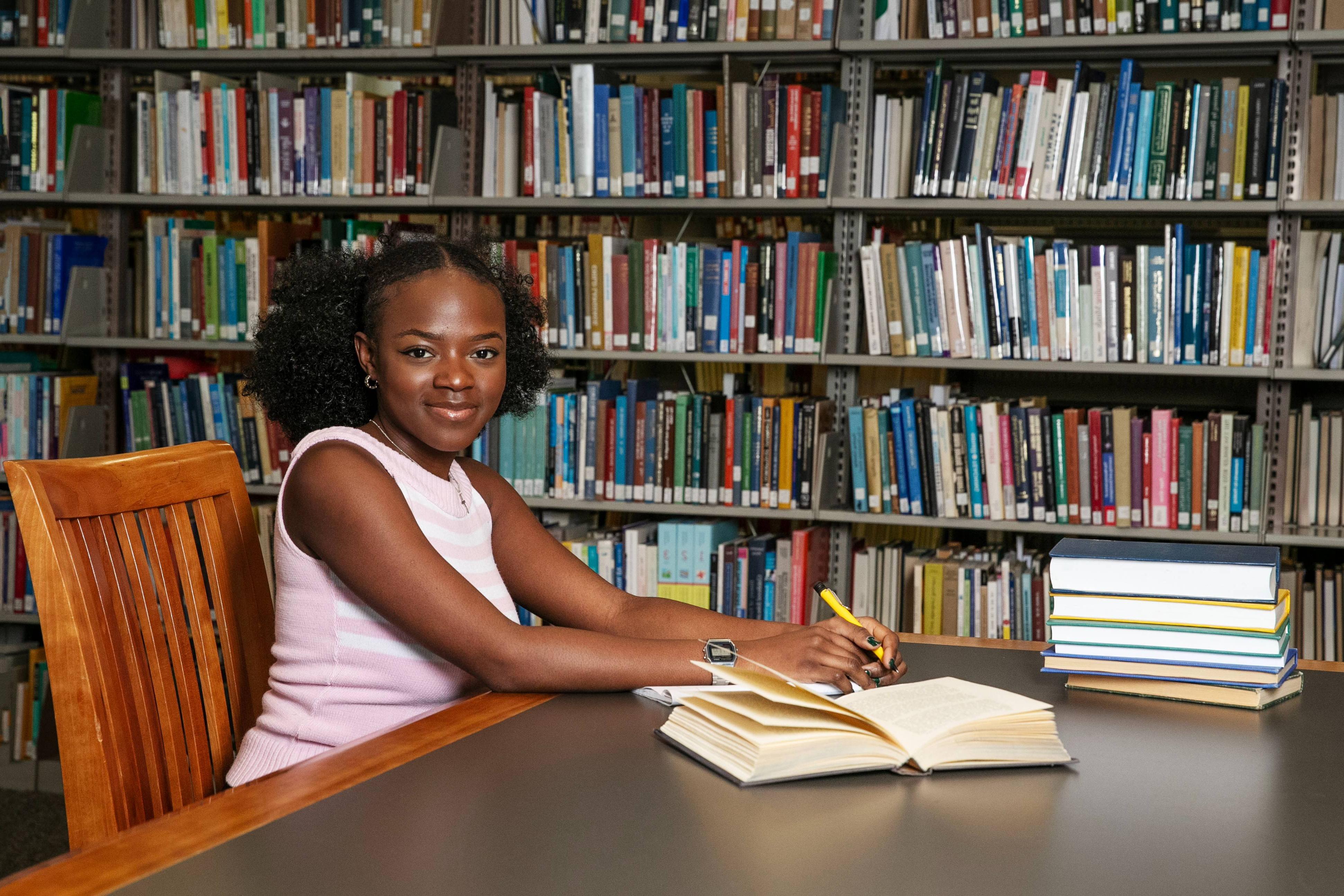 一张我的照片，阿内苏·穆康比瓦24岁，在火博体育的斯克里布纳图书馆，做着我喜欢的事情:写作. 